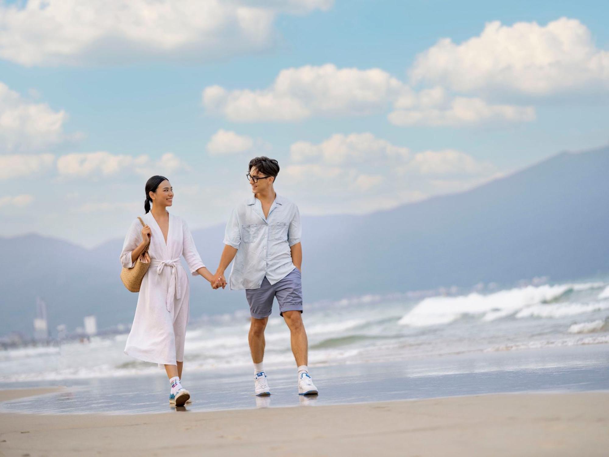 Dlg岘港酒店 外观 照片 A couple walking on the beach